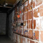 Exposed copper plumbing pipes on a brick wall